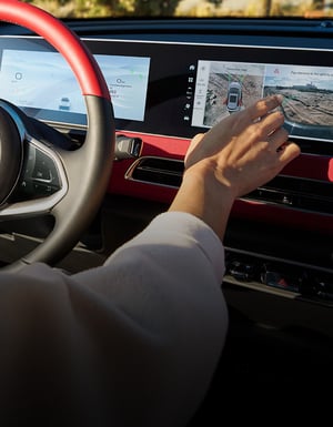 Hand am Display im Cockpit eines GWM ORA 03 GT in Two-Tone Black/Red