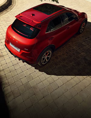 Der GWM ORA 03 GT in Mars Red mit Panorama-Glasschiebedach mitten in der City von oben betrachtet