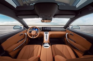 Der Blick durch die Frontscheibe und über das großzügige Cockpit eines GWM ORA 07 mit braun-schwarzem Interieur hinaus auf das offene Meer