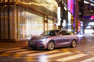 Der GWM ORA 07 GT in Dreamscape Purple beim Abbiegen in einer Kurve auf einem Zebrastreifen, dabei erkennt er drohende Kollisionen mit dem Gegenverkehr oder Fußgängern und führt bei Bedarf auch eine Notbremsung durch